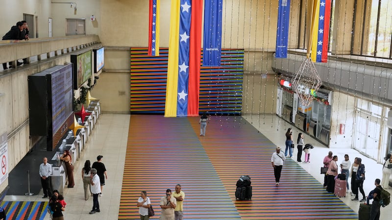 Viajeros esperan en la sala principal del Aeropuerto Internacional Simón Bolívar de Maiquetía,...