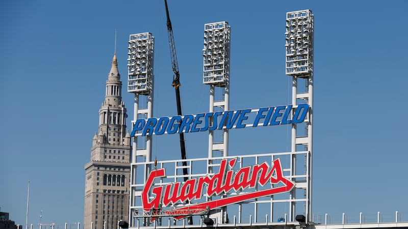 FILE - Workers finish installing the Cleveland Guardians sign above the scoreboard at...
