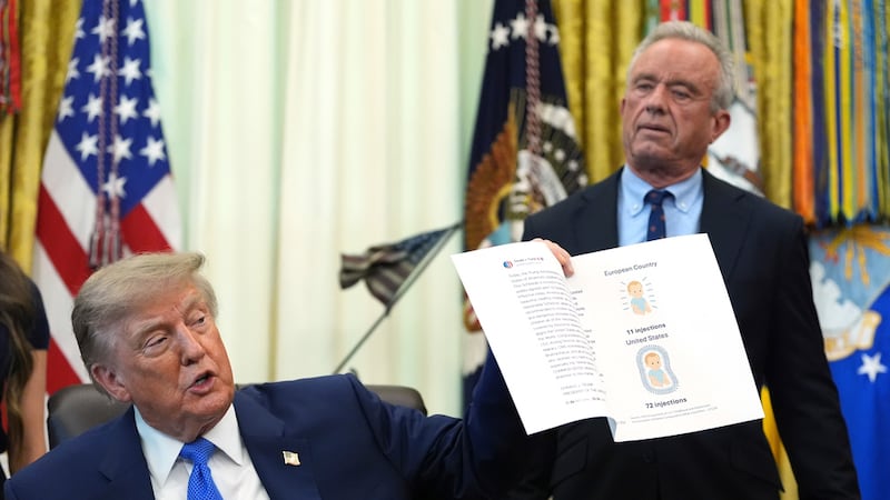 El presidente estadounidense Donald Trump sostiene una imagen tomada de su cuenta en Truth...