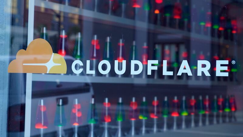 FILE - Lava lamps are seen through a lobby window at the headquarters of Cloudflare in San...
