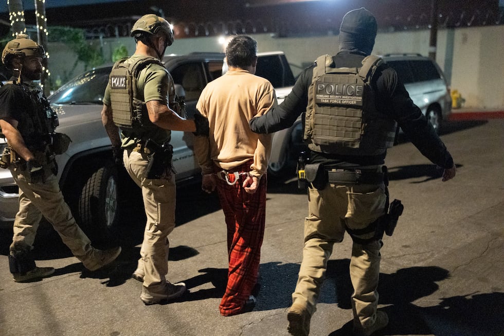 Policías escoltan a una persona acusada de votar ilegalmente en Commerce, California, el 19 de...