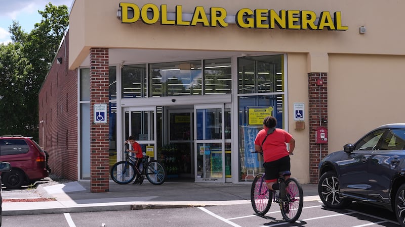 ARCHIVO - Unos niños van en bicicleta a la tienda Dollar General, el 21 de agosto de 2025, en...
