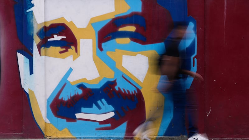 Un peatón pasa frente a un mural del presidente Nicolás Maduro, el domingo 4 de enero de 2026,...