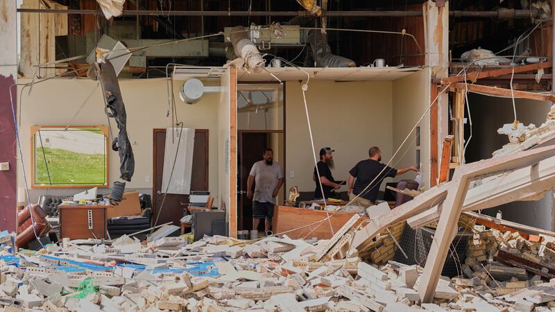 Trabajadores rescatan objetos el martes 14 de abril de 2026 en una fábrica de tuberías dañada...