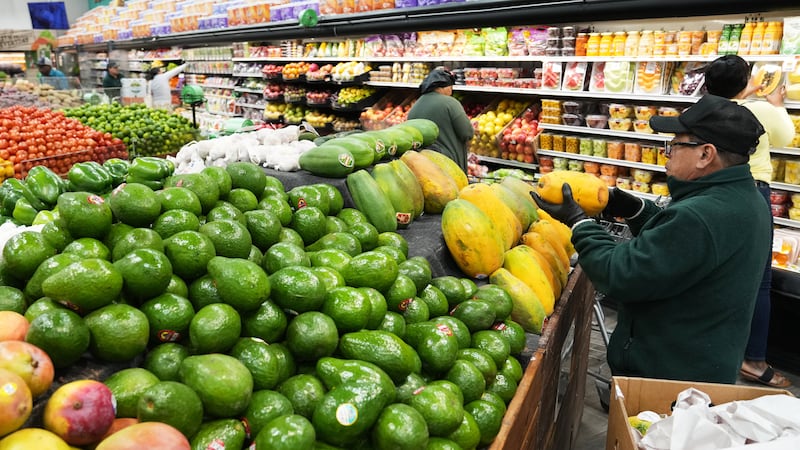 Un empleado coloca papayas en el supermercado Price Choice, que participa en el Programa de...