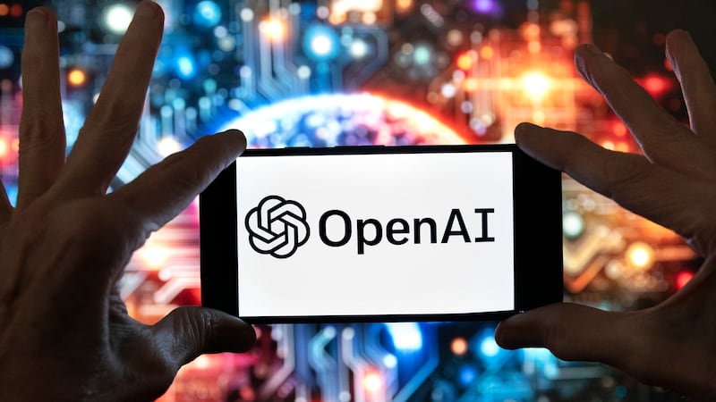 ARCHIVO - El logotipo de OpenAI aparece en un teléfono móvil frente a una imagen generada por...